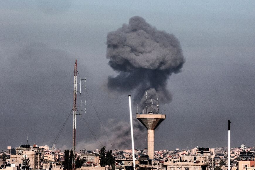 This picture taken from Rafah, in the southern Gaza Strip, shows smoke rising over buildings in Khan Yunis during Israeli bombardment on February 8, 2024