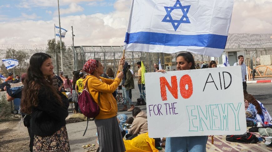 Israeli demonstrators gather by the border fence with Egypt at the Nitzana crossing in southern Israel to block humanitarian aid trucks from entering into Israel on their way to the Gaza Strip