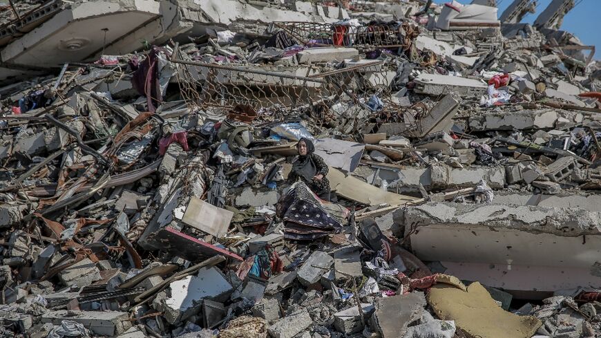 A Palestinian woman searches through the rubble after bombardment in Gaza City