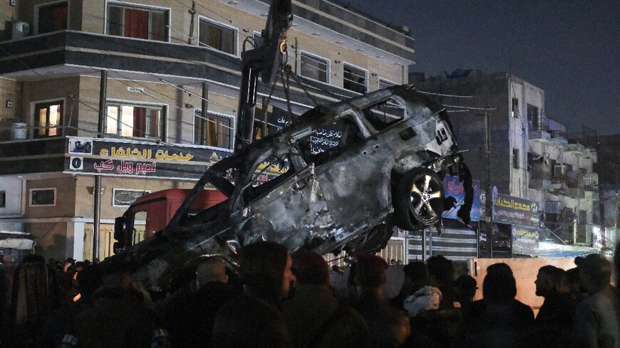 The vehicle hit in the strike in Baghdad is removed from the street