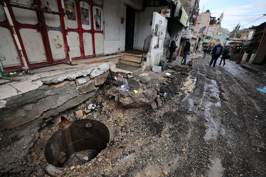 People find their way along a street devastated by the passage of Israeli military vehicles and bulldozers during raids, in the refugee camp of Balata in the occupied West Bank